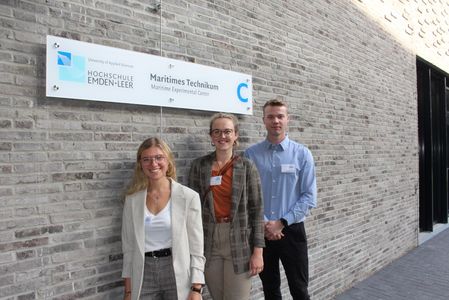 Drei stolze Studierende vor dem Maritimen Technikum der Hochschule Emden/Leer