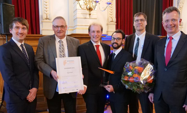 (v.l.): Prof. Dr. Oliver Kramer, Departement Direktor der Informatik an der Universität Oldenburg, Prof. Dr. Walter Neu, die Teammitglieder Lukas Eschment und Alejandro Delgadillo, Prof. Dr. Thomas Schüning (Hochschule Emden/Leer) und Prof. Dr. Carsten Wilken, Vizepräsident für Studium und Lehre sowie Internationales an der Hochschule Emden/Leer.